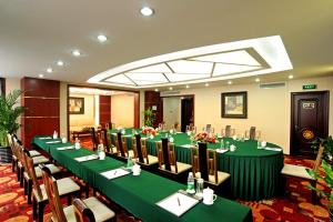 a room with green tables and chairs in a room at Super House International in Beijing