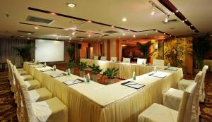 a room with a long table with white chairs and a screen at Super House International in Beijing
