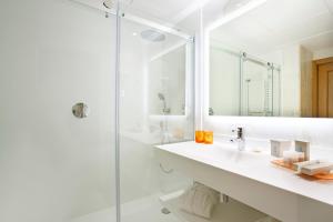 a white bathroom with a sink and a shower at Grupotel Parc Natural & Spa in Playa de Muro