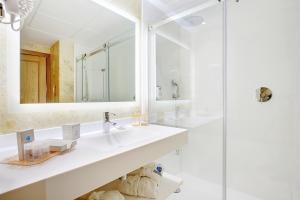 a bathroom with two sinks and a shower at Grupotel Parc Natural & Spa in Playa de Muro