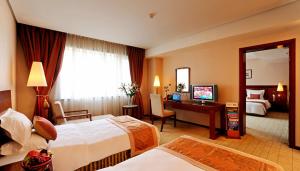 a hotel room with two beds and a desk at Super House International in Beijing