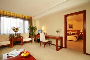 a hotel room with a bed and a living room at Super House International in Beijing