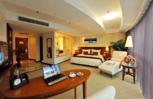 a bedroom with a bed and a desk with a laptop at Super House International in Beijing
