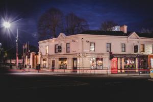 a large white building on a city street at night at JBs Bar & Guest Accommodation in Kilkenny