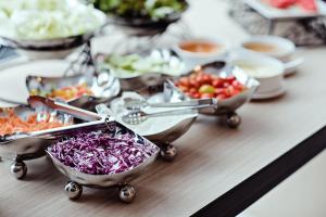 a table topped with bowls of vegetables and other foods at Three Sukhumvit Hotel in Bangkok