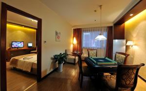 a hotel room with a bed and a table and a mirror at Super House International in Beijing