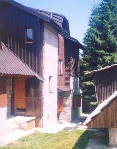 ein Gebäude mit einer Holztür und einem Baum in der Unterkunft Vila NADJA in Kopaonik + 15 Fotos
