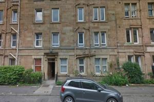 een zilveren auto geparkeerd voor een bakstenen gebouw bij Watson Crescent in Edinburgh