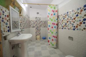 La salle de bains blanche est pourvue d'un lavabo et d'une douche. dans l'établissement Lhachik Guest House, à Leh