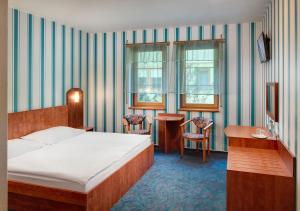 a bedroom with a bed and a table and chairs at Wellness Hotel Babylon in Liberec