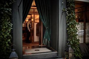 um homem parado na porta de uma casa em Hotel Sanders em Copenhague