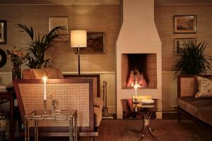 فندق ساندرز في كوبنهاغن: غرفة معيشة مع أريكة ومدفأة
