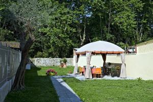 a gazebo with a table and chairs in a yard at LIù B&B in Torre del Lago Puccini