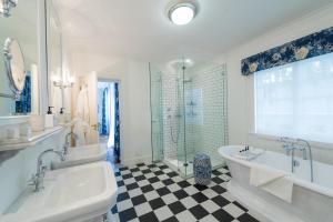 a bathroom with two sinks and a tub and a shower at Drostdy Hotel in Graaff-Reinet