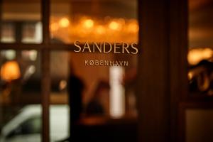 una ventana con las palabras de los santeros escritas en ella en Hotel Sanders, en Copenhague