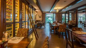 a restaurant with tables and chairs and wine bottles at Drostdy Hotel in Graaff-Reinet