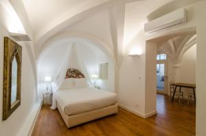 Casa Morgado Esporao في ايفورا: غرفة نوم بسرير ابيض وطاولة