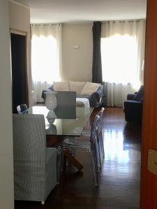Una sala de estar con una mesa de cristal y un sofá. en IN PIAZZA appartamento con vista, en Lazise