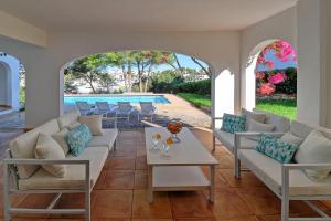 a patio with couches and a table and a pool at Villa Vistamar in Cala d´Or