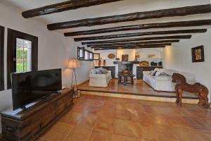 a living room with a flat screen tv and a horse statue at Villa Vistamar in Cala d´Or