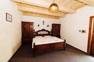 a bedroom with a wooden bed and a wooden ceiling at Apartmány pod Oravským hradom in Oravský Podzámok