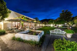 a house with a fountain in the yard at night at Drostdy Hotel in Graaff-Reinet