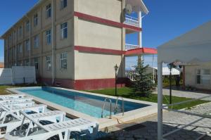 a building with a swimming pool next to a building at Aquamarine Inn in Cholpon-Ata