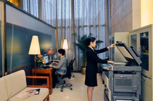 a woman standing in front of a computer in a room at Super House International in Beijing