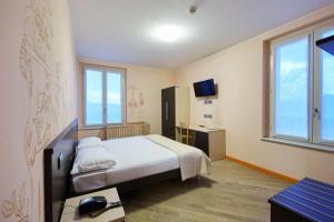 ValbremboにあるCornelle Hotelのベッドとテレビ付きのホテルルーム