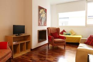 バルセロナにあるSweet BCN Three Bedroom Apartmentのリビングルーム(ソファ、椅子、テレビ付)