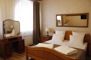 アレクサンドロフにあるMini-hotel Ostrovのベッドルーム1室(鏡付きベッド1台、ドレッサー付)