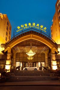 a building with a white car in front of it at Poly Hotspring Guiyang Hotel in Guiyang