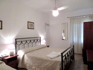 a bedroom with a bed and a table and a lamp at Albergo La Perla in Orbetello