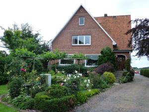 une maison avec un jardin devant dans l'établissement Pension Hauschildt, à Jork