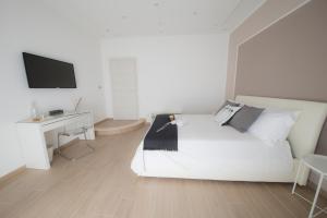 サレルノにあるシェリー B&B サレルノの白いベッドルーム(白いベッド1台、デスク付)