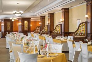 a banquet hall with white tables and white chairs at Balneo Complex Saint Spas in Velingrad
