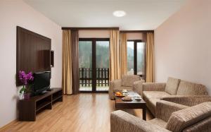 a living room with a couch and a tv at Balneo Complex Saint Spas in Velingrad