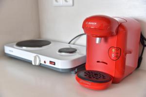 a red coffee maker and a toaster on a counter at KyMa Studios and Suites in Asprovalta