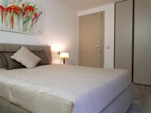 a bedroom with a bed and a lamp and a painting at Luxury Apartments Beauty Gardens in Sirmione +33 photos