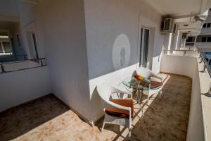 una piccola cucina con tavolo in vetro e sedie di Bianca Apartments a Herceg-Novi