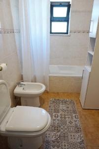 a bathroom with a toilet and a sink and a tub at Casa Tucano in Aljezur