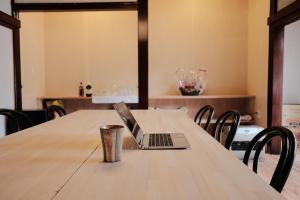 laptopa siedzącego na stole w obiekcie Shirakawago Guest House Kei w mieście Shirakawa
