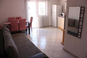 a kitchen with a couch and a table and a refrigerator at Apartments Tanja & Josipa in Pag