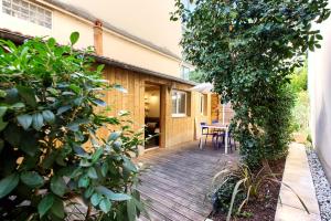 una terraza de madera con mesa y sillas en una casa en Location avec terrasse, en Arcachon