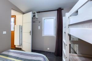 アルカションにあるLocation avec terrasseの小さなベッドルーム(二段ベッド1組、窓付)
