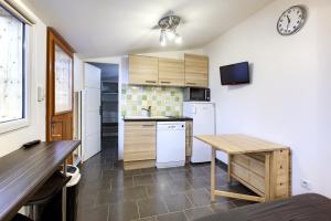 a kitchen with white appliances and a table in it at Location avec terrasse in Arcachon