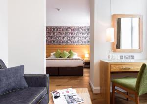 a hotel room with a bed and a desk and a couch at ABode Canterbury in Canterbury