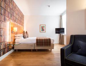 a bedroom with a bed and a couch and a tv at ABode Canterbury in Canterbury