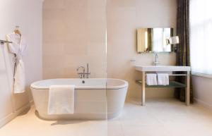 a bathroom with a bath tub and a sink at ABode Canterbury in Canterbury