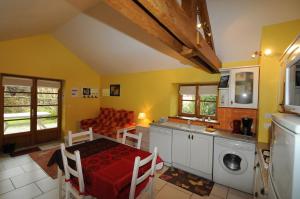 a kitchen and living room with a table and a washing machine at Gite THEYS Floing in Floing